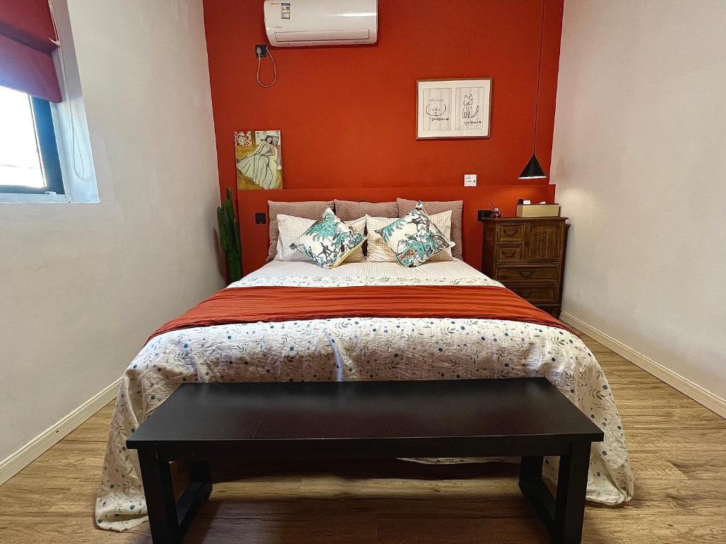 a bedroom with a bed with an orange wall at Shanghai Guiwu Village Near Disney Resort in Shanghai