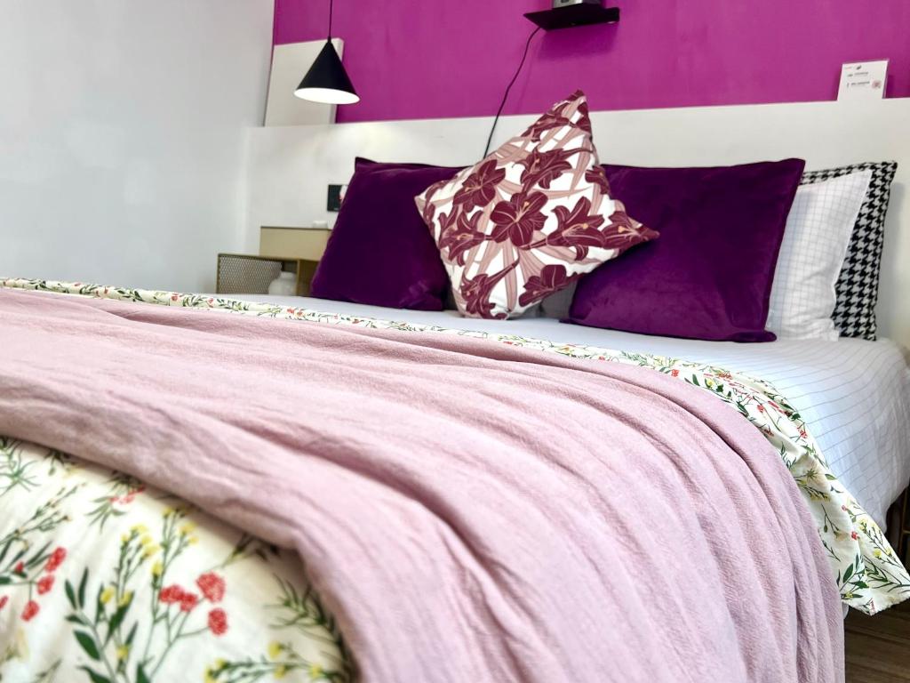 a bed with purple walls and purple pillows at Shanghai Guiwu Village Near Disney Resort in Shanghai