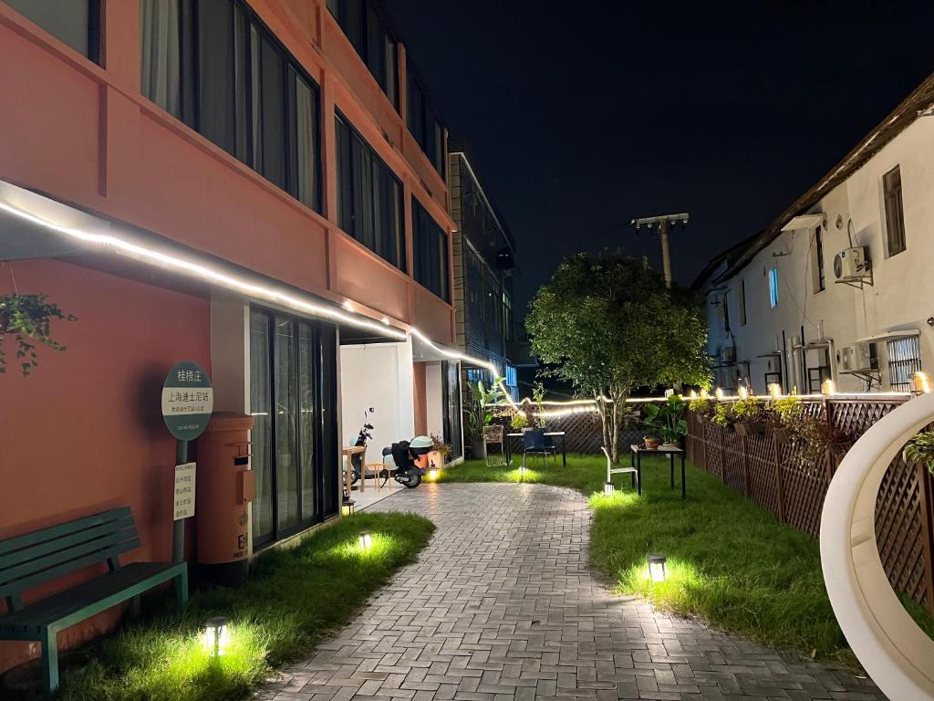 a walkway with lights next to a building at night at Shanghai Guiwu Village Near Disney Resort in Shanghai