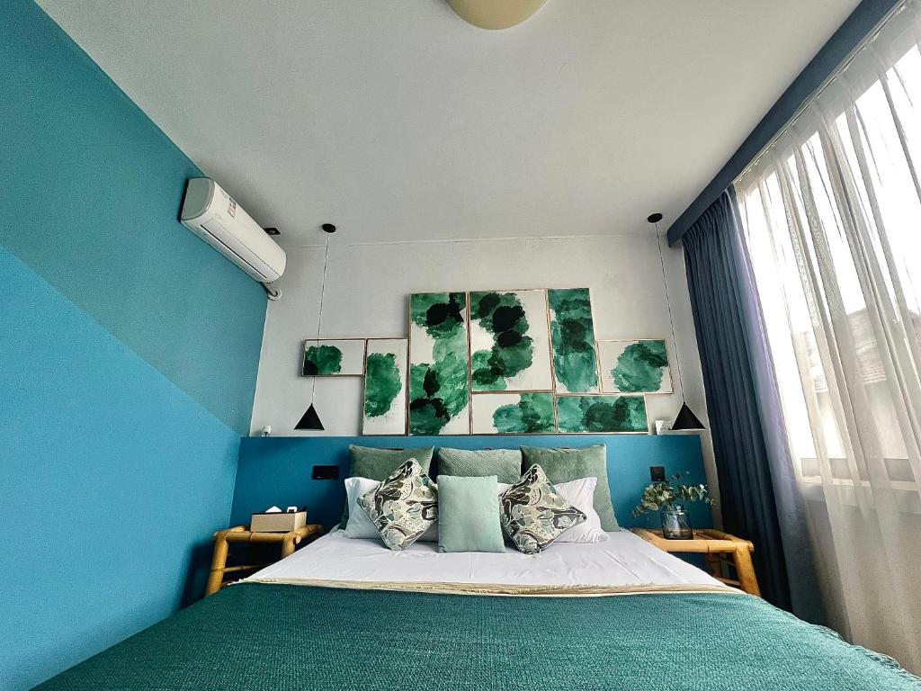 a bedroom with blue walls and a bed with pillows at Shanghai Guiwu Village Near Disney Resort in Shanghai