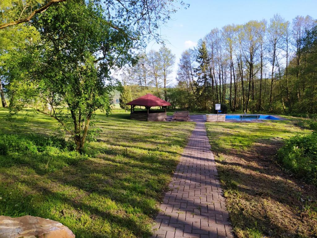 a brick path in a park with a picnic shelter at Haus Kellerwald - Ferienwohnung Kellerwald-Edersee in Jesberg