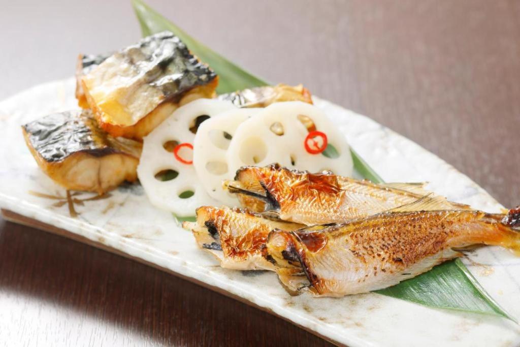 a plate of food with fish and other foods at HOTEL MYSTAYS PREMIER Kanazawa in Kanazawa