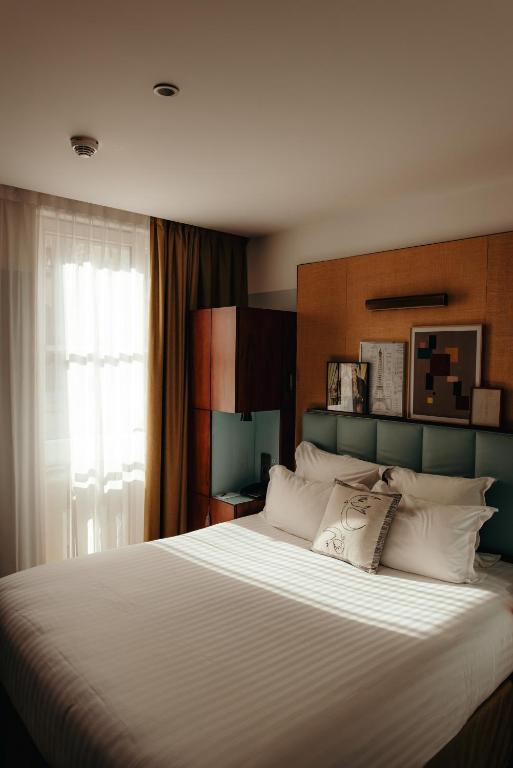Postel nebo postele na pokoji v ubytování Hotel Eiffel Blomet