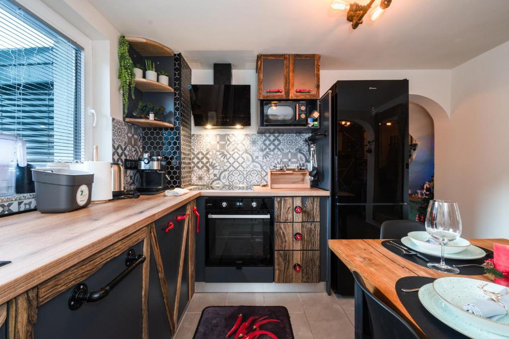 a kitchen with a wooden counter and a black refrigerator at Deluxe House Maj in Brežice