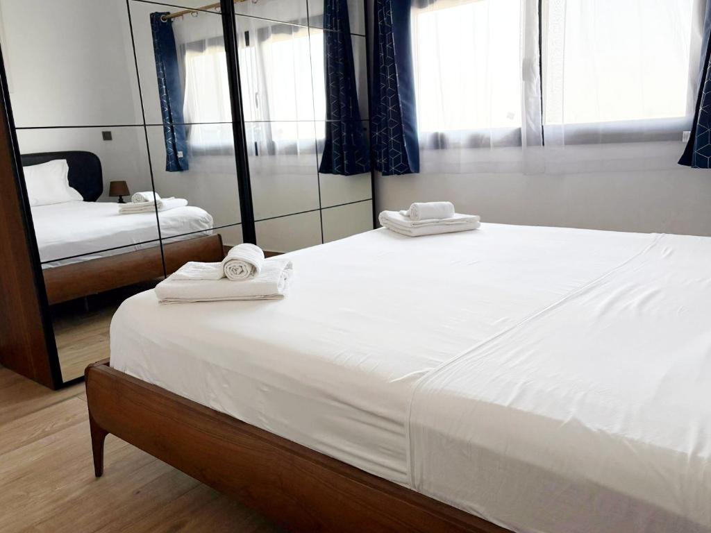 Un dormitorio con una gran cama blanca con toallas. en DakarByDays-DBD003-Appartement Adèle 1 chambre, en Dakar