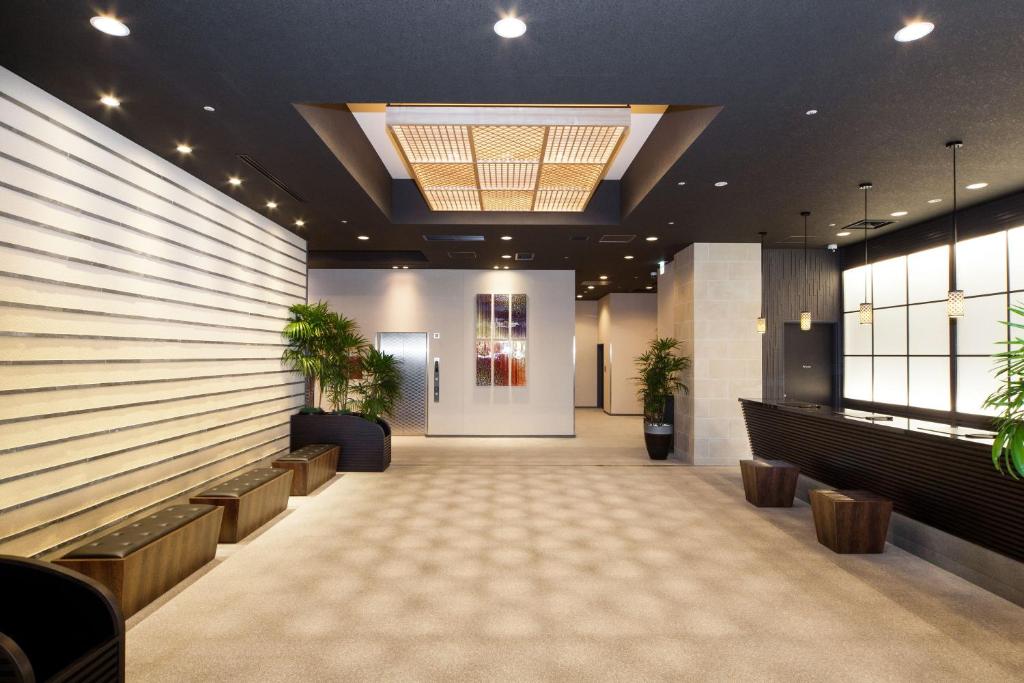 a lobby with a waiting room with potted plants at HOTEL MYSTAYS PREMIER Kanazawa in Kanazawa