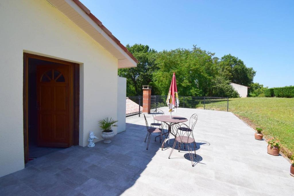 a patio with a table and chairs and an umbrella at Appartement à Caudecoste, proche d'Agen in Caudecoste