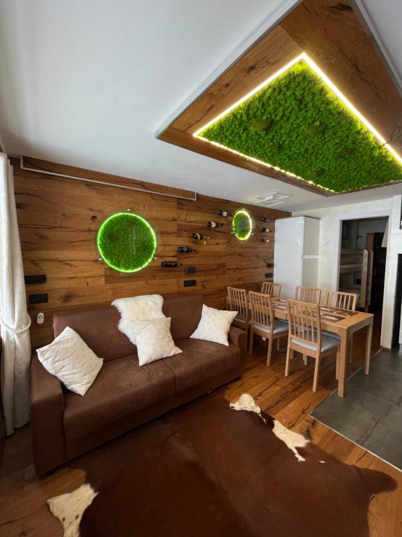 un salon avec un canapé marron et une table dans l'établissement Chalmettes Lune Étoilée, à Montgenèvre