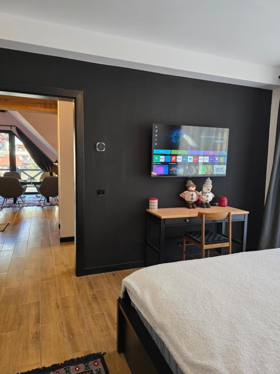 a bedroom with a tv on a black wall at Vila Ferdinand Apartments in Sinaia