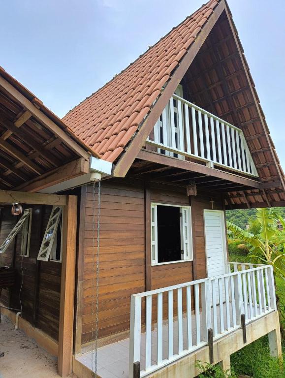 a small house with a porch and a deck at Chalé Sítio Recanto dos Sonhos in Aimorés