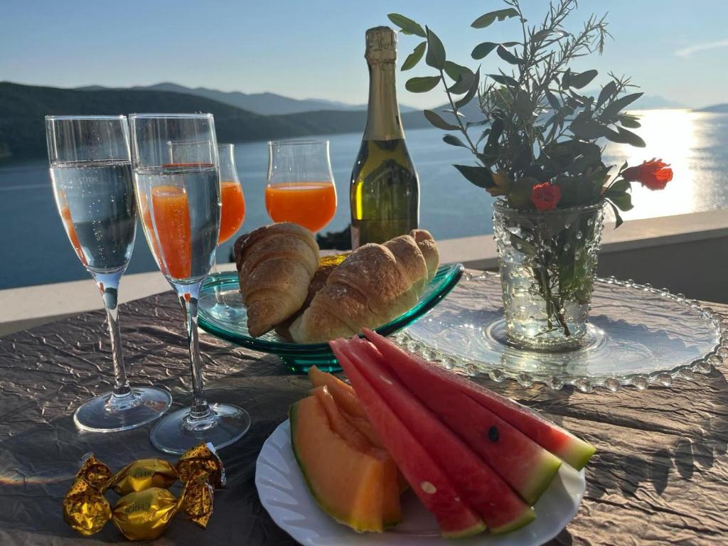 a table with glasses of wine and a plate of fruit at Villa Grande in Neum