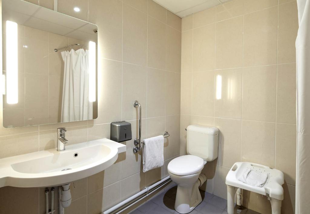 a bathroom with a sink and a toilet and a mirror at B&B HOTEL Paris Le Bourget in Le Bourget