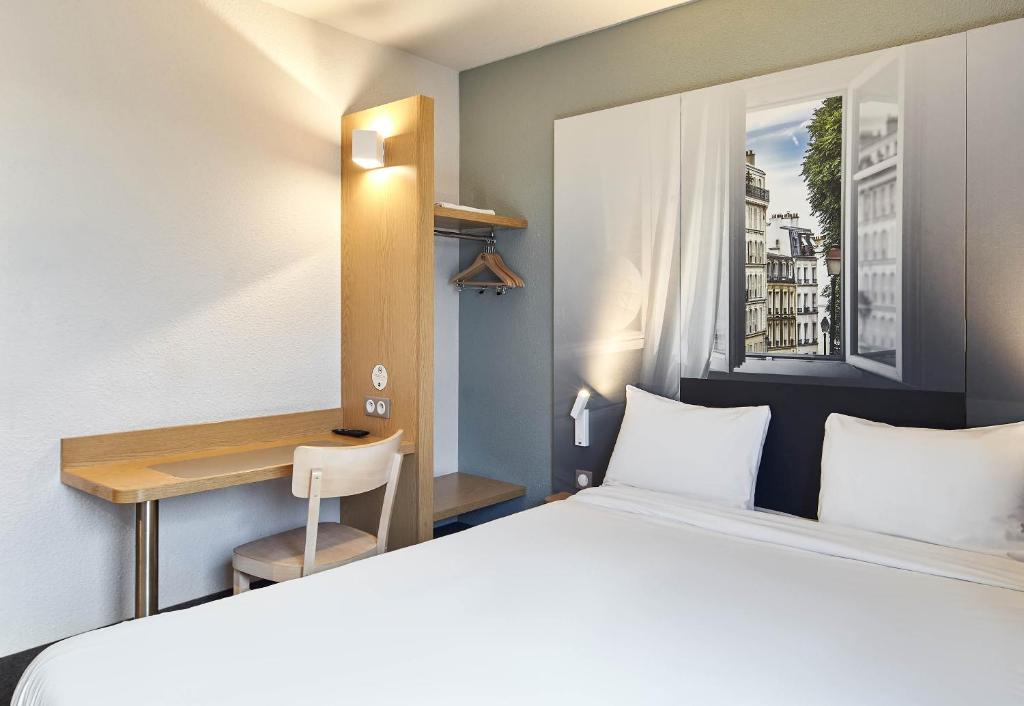 a hotel room with a bed and a desk at B&B HOTEL Paris Le Bourget in Le Bourget
