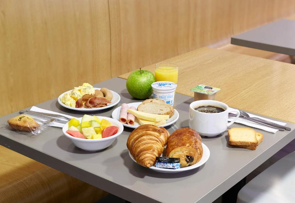 a tray of breakfast foods on a table at B&B HOTEL Paris Le Bourget in Le Bourget