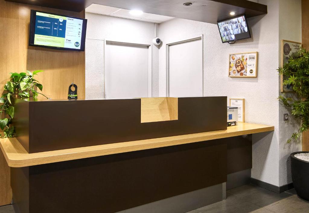 a cashier counter in a waiting room at B&B HOTEL Paris Le Bourget in Le Bourget