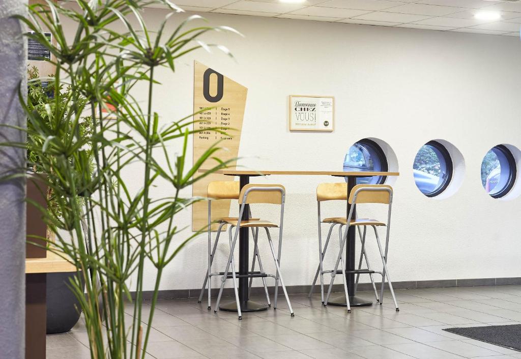 a table and stools in a waiting room at B&B HOTEL Paris Le Bourget in Le Bourget