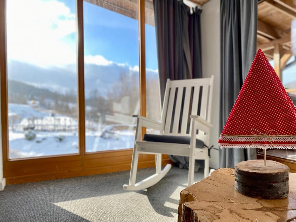 Zimmer mit Schaukelstuhl und Fenster in der Unterkunft Gościniec Rajec in Rajcza