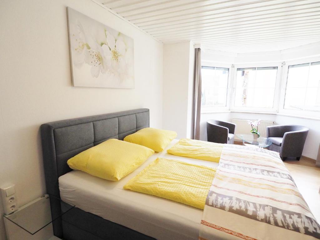 een slaapkamer met een bed met gele kussens erop bij Appartements Peter in Sankt Kanzian