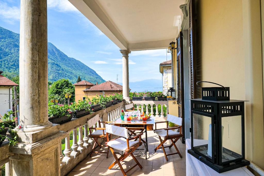 a patio with a table and chairs on a balcony at Casa Miralago in Castelveccana