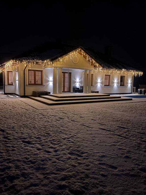 a house with christmas lights on it at night at Dworek pod Krzyżtoporem Ujazd Agroturystyka- pokoje do wynajęcia in Iwaniska