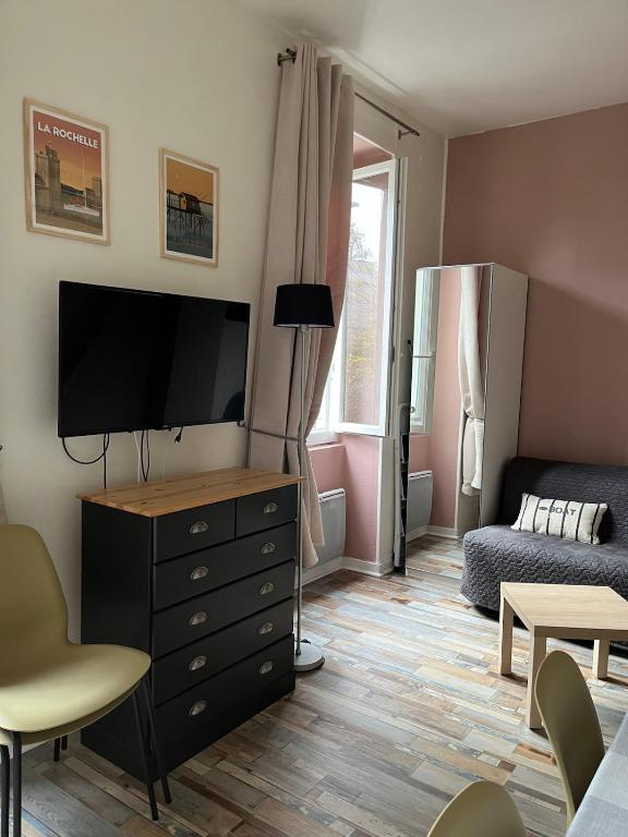 d'un salon avec une télévision à écran plat et une commode. dans l'établissement Studio La Corniche - accès ocean et plage, à La Rochelle