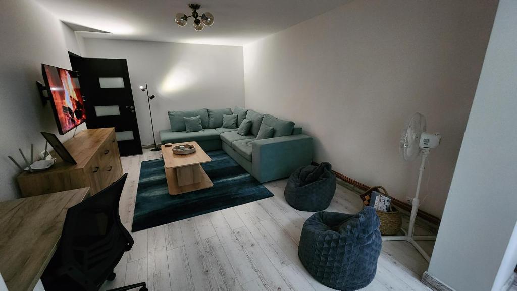 a living room with a blue couch and a table at Retreat Apartment in Tîrgu Ocna