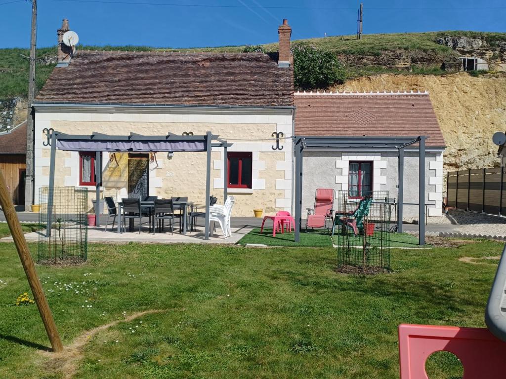 a house with a table and chairs in a yard at Le paradis des caves in Châteauvieux