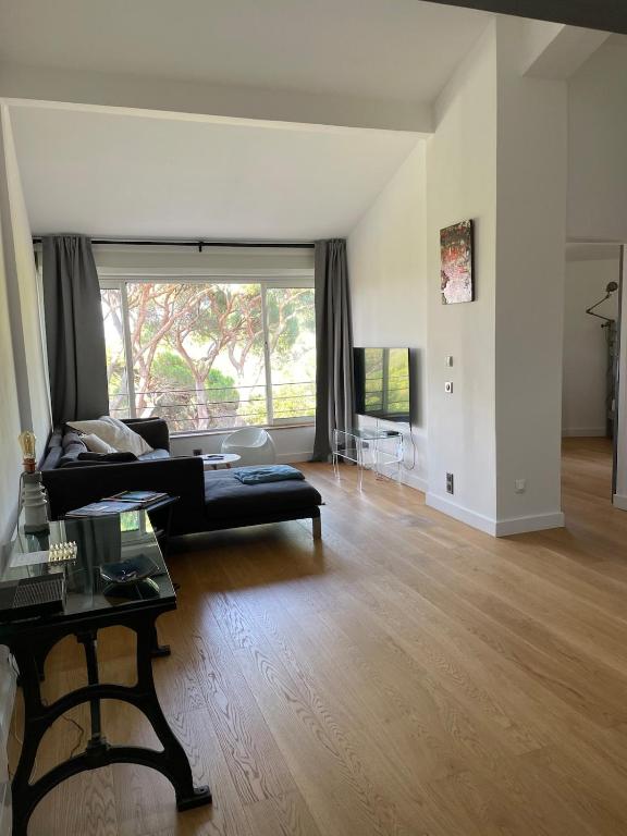 un salon avec un canapé noir et une table dans l'établissement Très beau duplex, 2 chambres, parking privé, plage à 5 minutes, à Sainte-Maxime