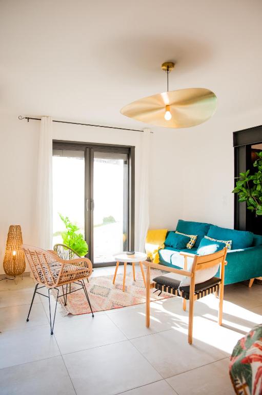 un salon avec un canapé bleu et des chaises dans l'établissement NoMad Home, avec 1 parking privé à 2 pas de La Cité Médiévale, à Carcassonne