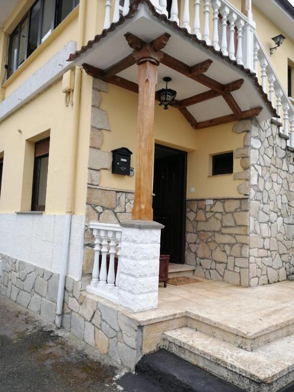 ein Haus mit einer Veranda mit Steinmauer in der Unterkunft Ca'Gloria in El Valle