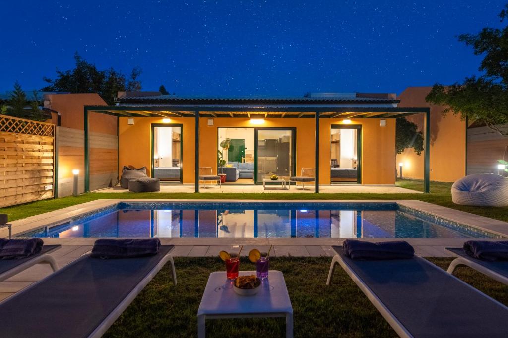 a house with a swimming pool at night at Galene Eco Luxury Villas in Acharavi