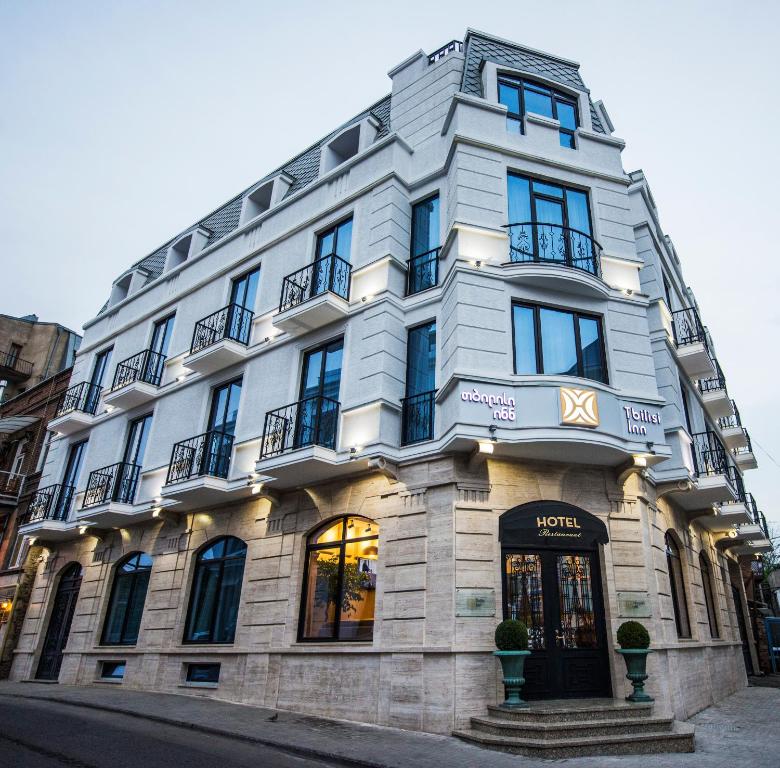 un gran edificio blanco en una calle de la ciudad en Tbilisi Inn, en Tiflis