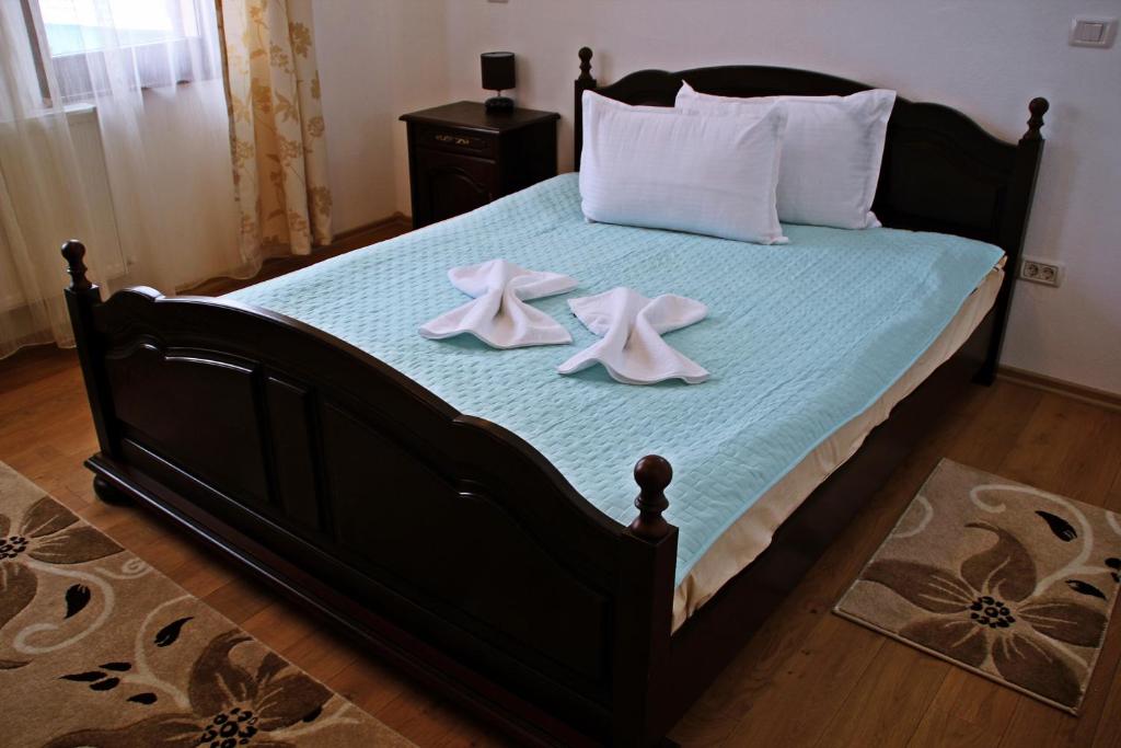 a bedroom with a bed with two towels on it at Pensiunea Crimar in Ilteu