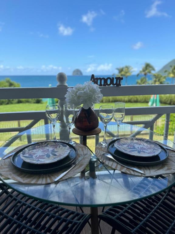une table avec des assiettes et des verres et un vase avec des fleurs dans l'établissement TiKazAmour - Bienvenue chez vous, à Précigné