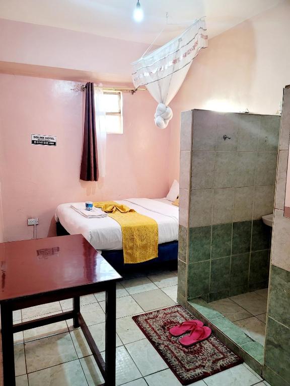Postel nebo postele na pokoji v ubytování Nairobi Sislink Hotel