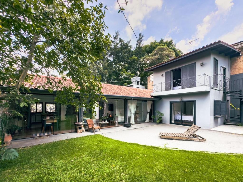 ein Haus mit einem grünen Hof mit einem Haus in der Unterkunft Charme na Granja - Condomínio in Carapicuíba