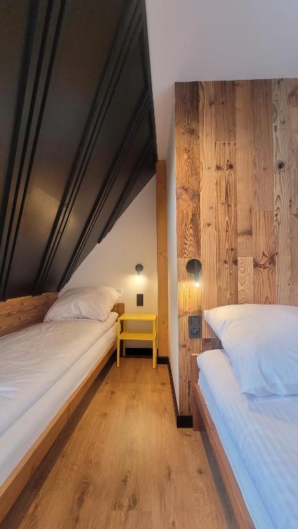 a bedroom with two beds and a yellow table at Chałupka Apartament 3 in Krempachy