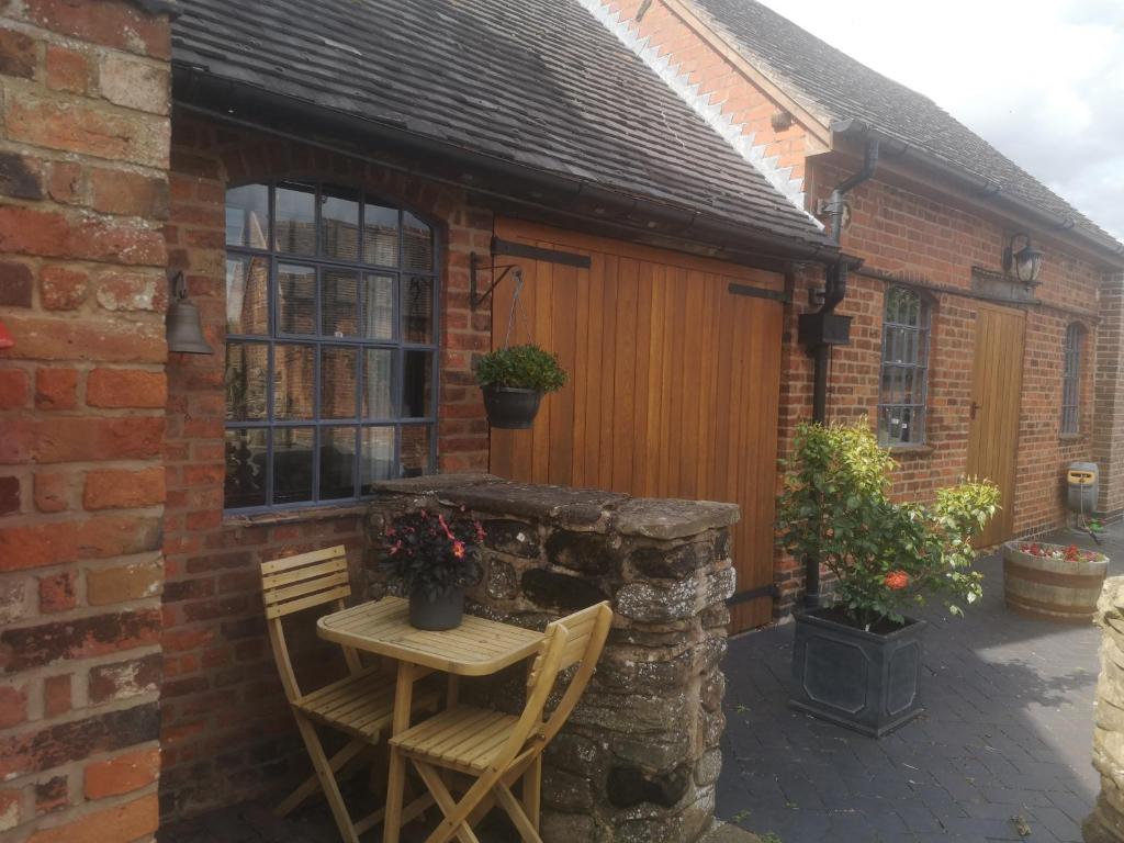 a small patio with a table and two chairs at Hood Lane Farm - The Parlour - Self Catering Ground Floor Apartment in Arley