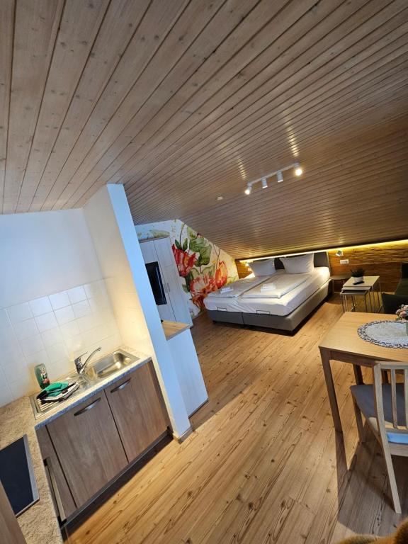 a kitchen and a living room with a bed and a table at Landhaus Black Forest in Schluchsee