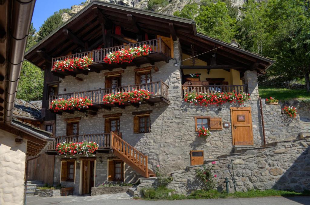 a stone building with flower boxes on the balconies at Residence CAV Emile Rey in Courmayeur