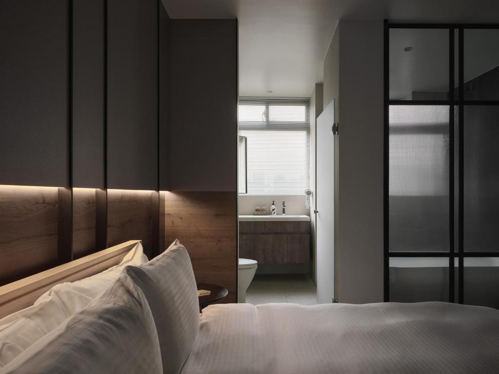 a bedroom with a bed and a bathroom with a sink at Guangfa Apartment in Tainan