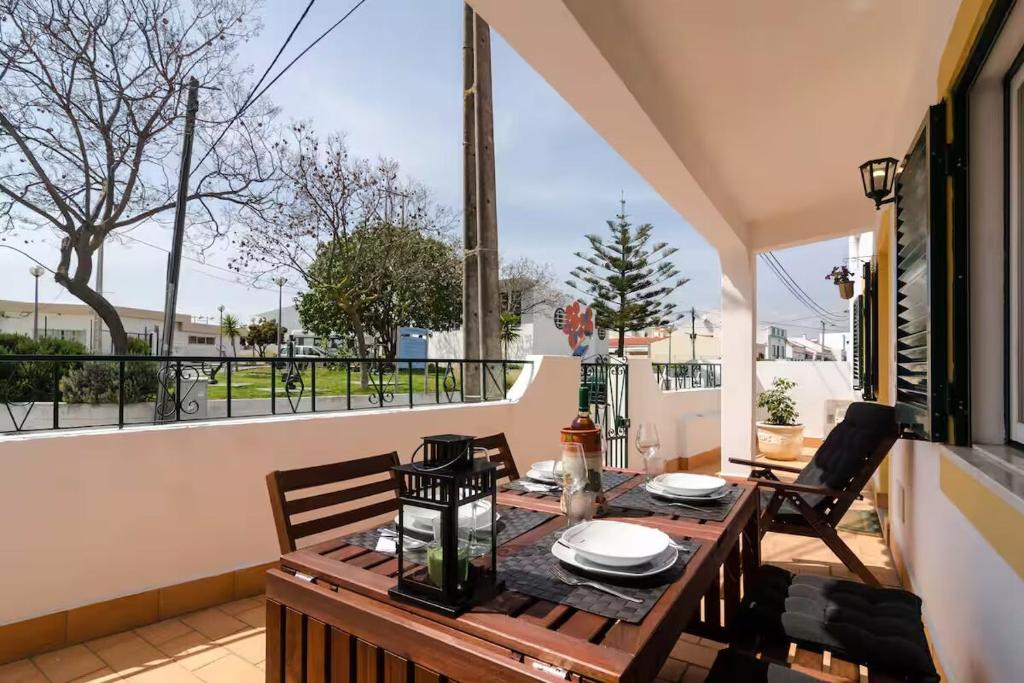 ein Holztisch und Stühle auf einem Balkon mit Aussicht in der Unterkunft Villa Figueira in Portimão
