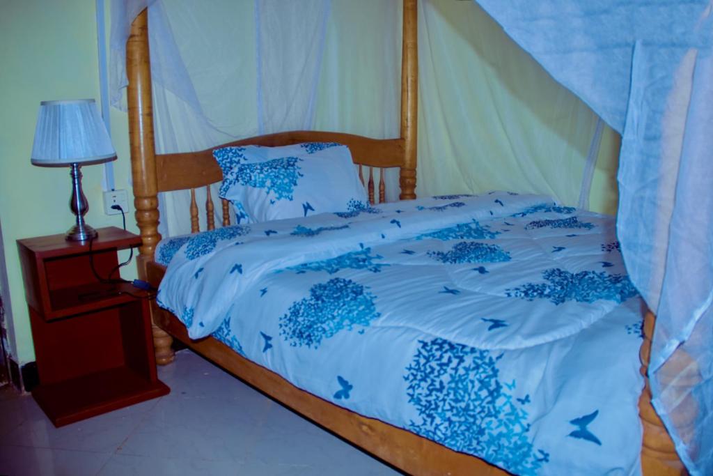 un letto con piumone e cuscini blu sopra di Biez Homestay a Karatu