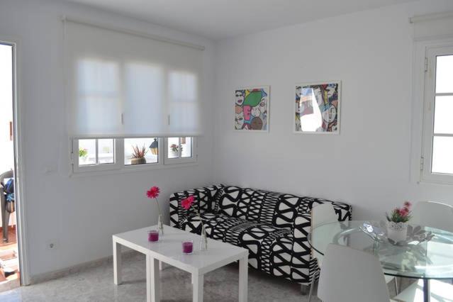 ein Wohnzimmer mit einem schwarz-weißen Sofa und einem Tisch in der Unterkunft Elena Beach House Lanzarote in Playa Honda
