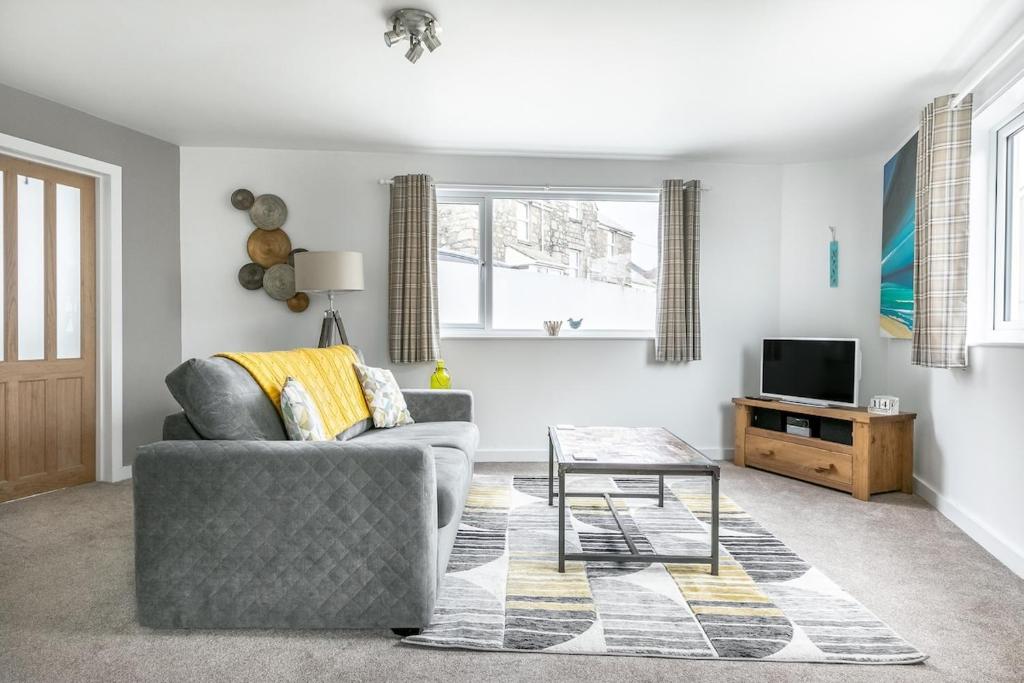 una sala de estar con un sofá y una mesa en Life of Riley, en St Ives