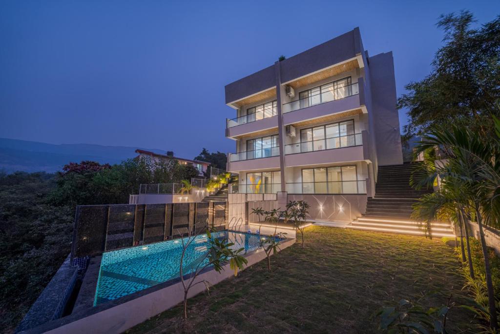 a house with a swimming pool in front of it at SaffronStays Prisma Luxury 8 bedroom Villa with Pool in Lonavala in Malavli