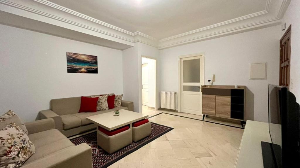 a living room with a couch and a table at Belle Appartement pour Familles S2 El Nasser 1 Ariana in Ariana