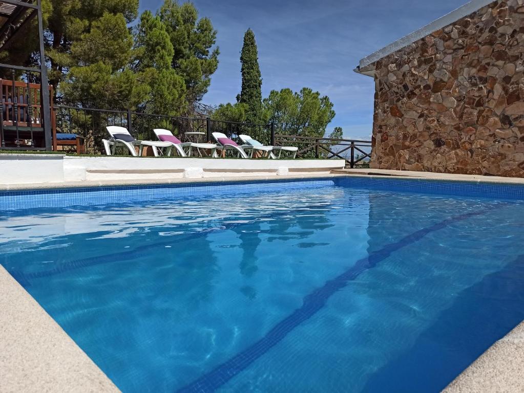 een zwembad met blauw water in een resort bij Casa Rural MONTE VERDE in Illana