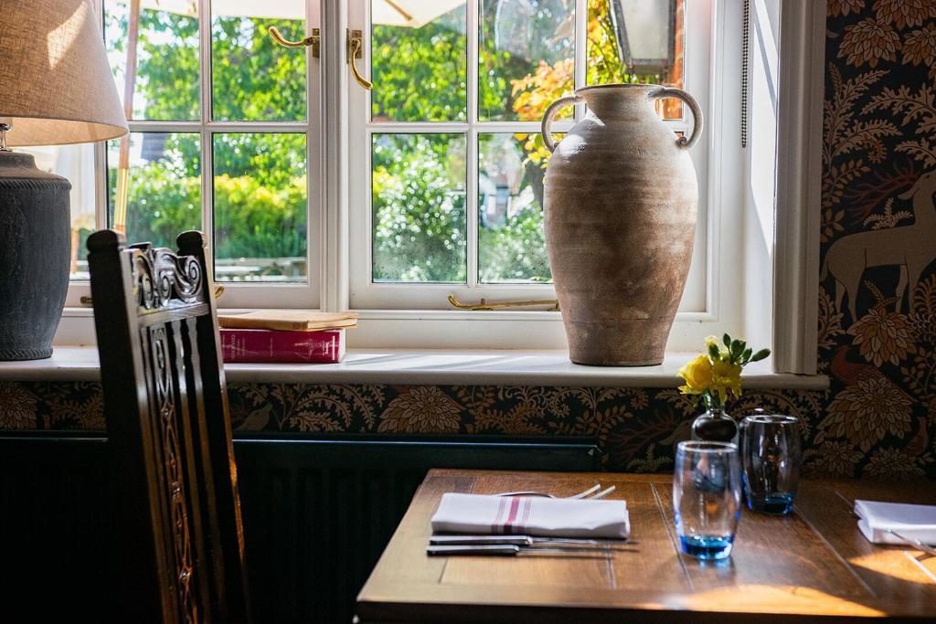 un tavolo con un grande vaso seduto su un davanzale di The Stag and Huntsman at Hambleden a Henley on Thames