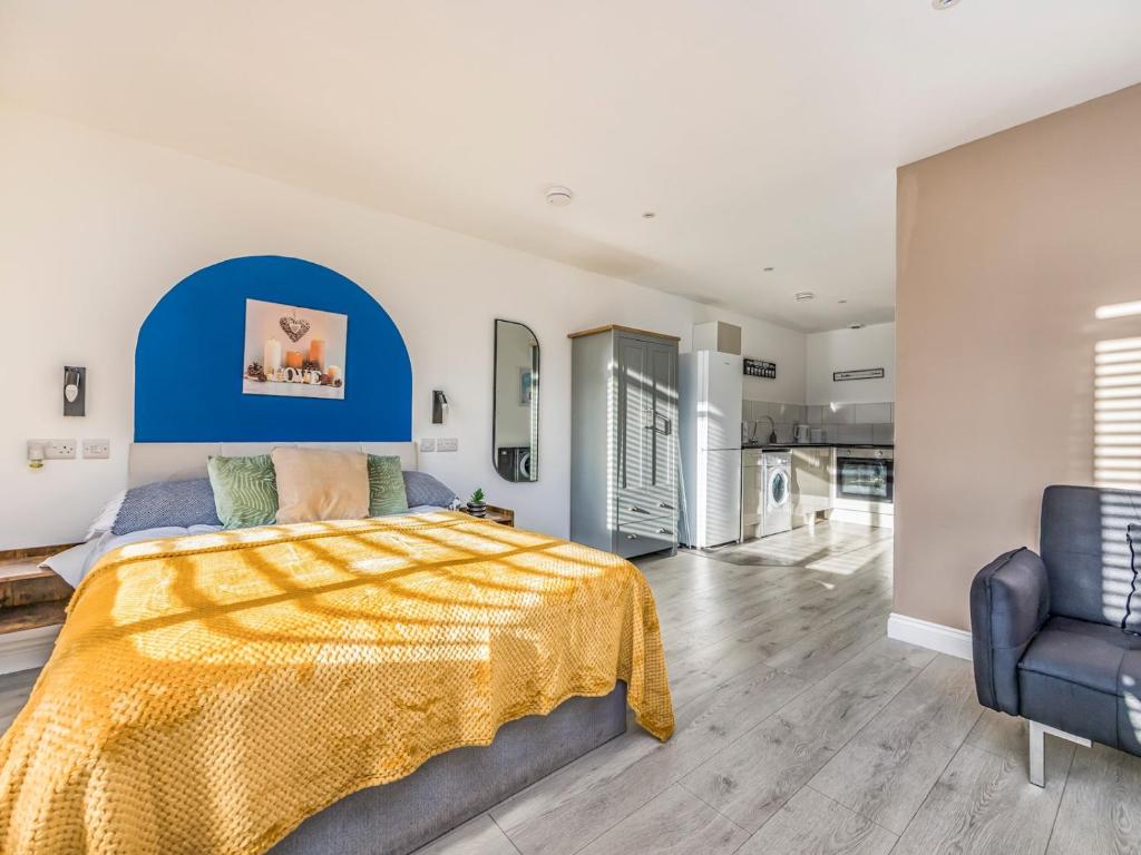 Contemporary Modern Studio في بورتسماوث: غرفة نوم بسرير كبير الحجم ولوح رأس أزرق